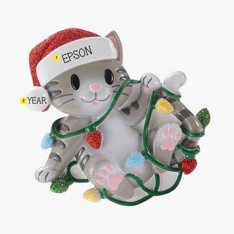 Personalized gray cat tangled in Christmas lights ornament with a pet name written on the Santa hat brim and a year added to the white pom-pom.