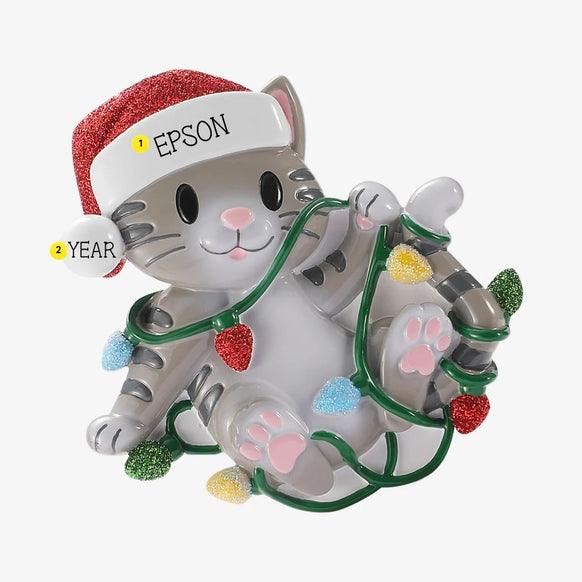 Personalized gray cat tangled in Christmas lights ornament with a pet name written on the Santa hat brim and a year added to the white pom-pom.