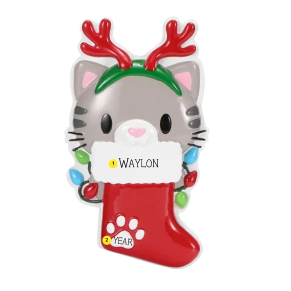 Personalized cat with reindeer antlers ornament with a pet name written on the stocking cuff and the year added near the paw print.