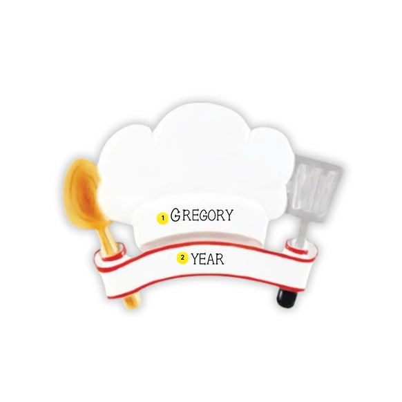Personalized chef hat ornament with a white chef hat, cooking spoon, spatula, and blank banner for a name and year.