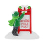 Child in a green winter coat, scarf, and hat drops a letter into a red North Pole post mailbox on a snowy white base.