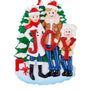 JOY family of 3 ornament with two parents and one child in winter clothes holding red glitter letters in front of snowy evergreen trees with wrapped gifts.
