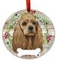 Cocker Spaniel Dog ornament with a wreath of holly and berries on a wooden background