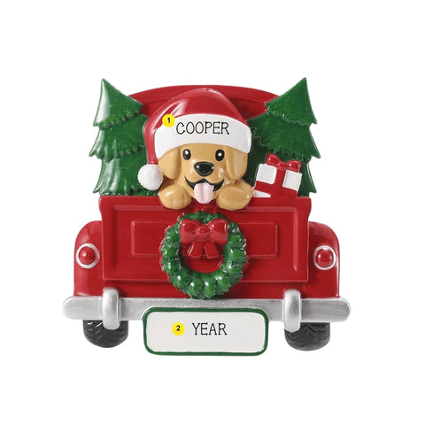 Personalized red Christmas truck ornament with a golden dog in a Santa hat, evergreen trees, a gift, an example name on the hat, and year on the license plate.