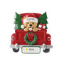 Personalized red Christmas truck ornament with a golden dog in a Santa hat, evergreen trees, a gift, an example name on the hat, and year on the license plate.