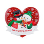 Engagement snowman couple ornament with two snowmen in winter accessories, a red heart background, snowflakes, and “We’re Getting Married!” on the banner.