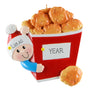 Decorative ornament with a boy holding a bucket of chicken nuggets , can be personalized with name and year