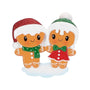 Gingerbread couple ornament with two smiling gingerbread people wearing Santa hats, standing together on a snowy base.