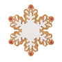 Gingerbread snowflake ornament with white icing details and red candy accents.