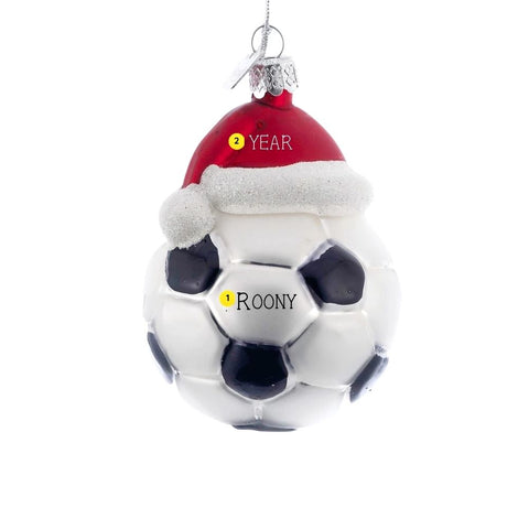 Personalized glass soccer ball ornament with black and white panels, red Santa hat, glittery white trim, silver cap, and hanging cord.