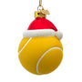 Glass tennis ball Christmas ornament featuring a bright yellow ball design, white curved lines, glittery Santa hat trim, and gold hanging cord.