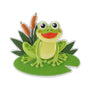 Happy frog ornament sitting on a green lily pad with cattails and leafy pond details.