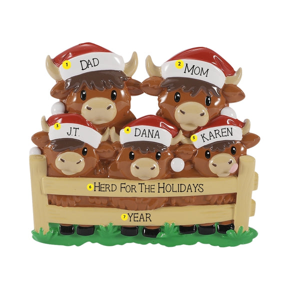 Personalized Highland cow family ornament with names on the Santa hats, a holiday phrase on the fence, and year below.