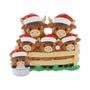 Highland cow family ornament with six cows in Santa hats, including two little cows in buckets, gathered behind a fence.