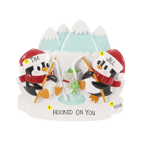 Personalized ice fishing penguin couple ornament with example names on the hats, a short phrase across the snow, and a year.