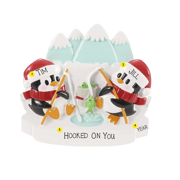 Personalized ice fishing penguin couple ornament with example names on the hats, a short phrase across the snow, and a year.