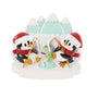 Ice fishing penguin couple ornament with two penguins in Santa hats fishing beside an ice hole with snowy mountains behind them.