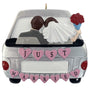 Decorative ornament of a couple in a car with 'Just Married' text, on a white background.