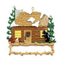 Decorative ornament of a log cabin with a bear and trees on a white background