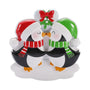 Mistletoe kissing penguins couple ornament with red and green Santa hats, matching scarves, and snowy base.