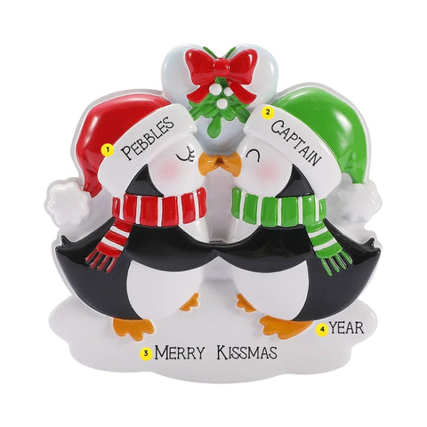 Personalized mistletoe kissing penguins ornament with names on Santa hats, “Merry Kissmas” phrase, and year placement shown.