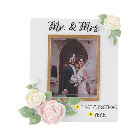 White Mr. & Mrs. wedding picture frame ornament with pastel flowers, a couple’s photo, and example personalization on the banner with a year.