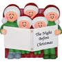 Decorative ornament of a family in Christmas hats reading 'The Night Before Christmas'.