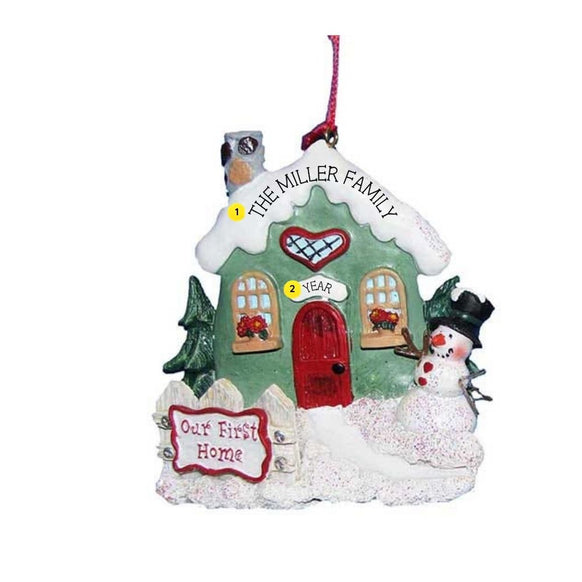 Personalized Our First Home Snowy Cottage Ornament with green cottage, red door, snowy roof, snowman, and Our First Home sign.