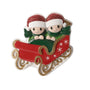 Red sleigh ornament for two with glitter Santa hats, green scarves, snowflake details, and gold runners.