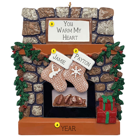 Decorative Christmas ornament of a stone fireplace with stockings and personalized names.
