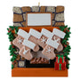 Decorative Christmas ornament of a stone fireplace with stockings and a wreath.