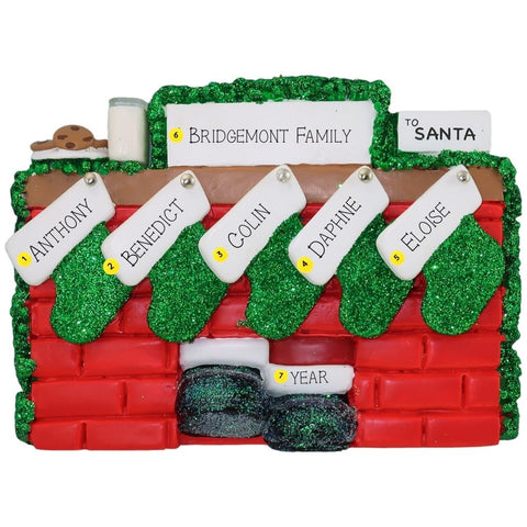 Christmas ornament of a mantel personalized with names, year, & family name against a white background