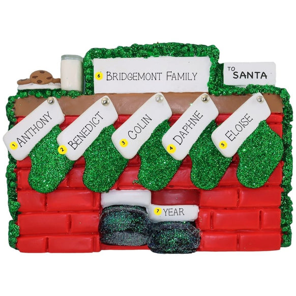 Christmas ornament of a mantel personalized with names, year, & family name against a white background
