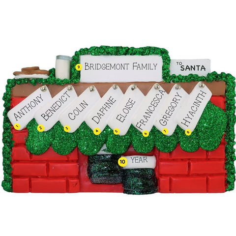 Christmas ornament of a mantel personalized with names, year, & family name against a white background