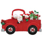 Decorative Christmas ornament of a red truck with Santa Claus and children, on a white background.