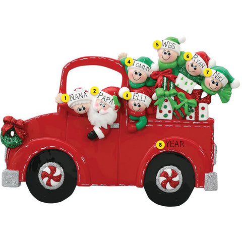 Decorative Christmas ornament of a red truck with Santa and elves on a white background