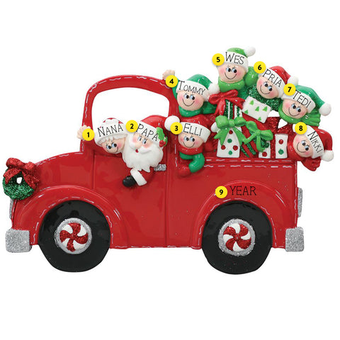 Decorative Christmas ornament of a red truck with Santa and elves on a white background