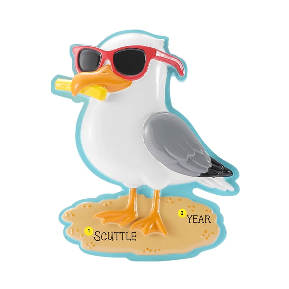 Personalized seagull ornament wearing red sunglasses and holding a French fry, with a name and year added to the sandy beach base.