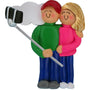 Ornament of a couple taking a selfie with a selfie stick on a white background