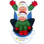 Personalized ornament of two smiling figures riding a blue sled through snow, with one larger figure behind a smaller figure in matching winter clothes.