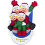 Personalized ornament of four smiling figures riding a blue sled through snow, in matching winter clothes.