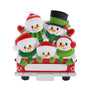 Snowman family of five ornament riding in a red holiday truck with festive red and green details.