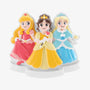 Three princess friends stand together in pink, yellow, and blue gowns on a white base.