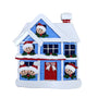 Decorative Christmas house ornament with smiling faces and a red door on a white background