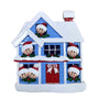Decorative Christmas house ornament with faces and a red door.