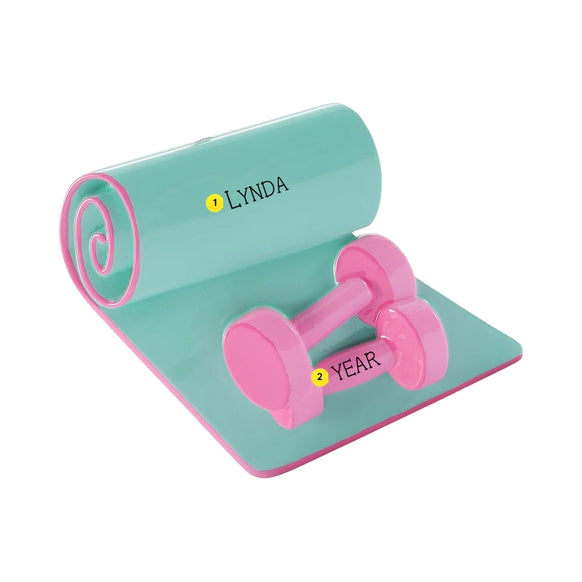Personalized yoga mat with pink dumbbells ornament with a name on the rolled mat and the year on a dumbbell.