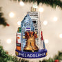 Christmas ornament with Philadelphia skyline and Liberty Bell on a tree with lights in the background