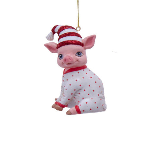 Pig ornament in white pajamas with red dots, wearing a red and white striped nightcap and sitting with a sweet expression.