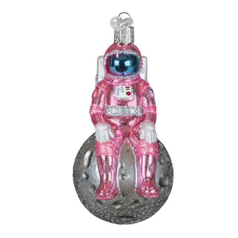 Glass ornament of an astronaut in a pink suit on a white background
