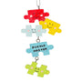 Colorful puzzle piece ornament with smiling faces on a white background